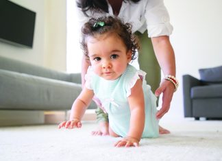 Sweet baby crawling on floor at home