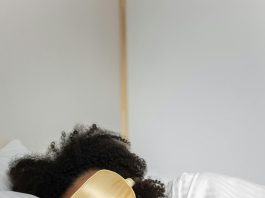 Person laying in bed with a sleeping mask over their eyes